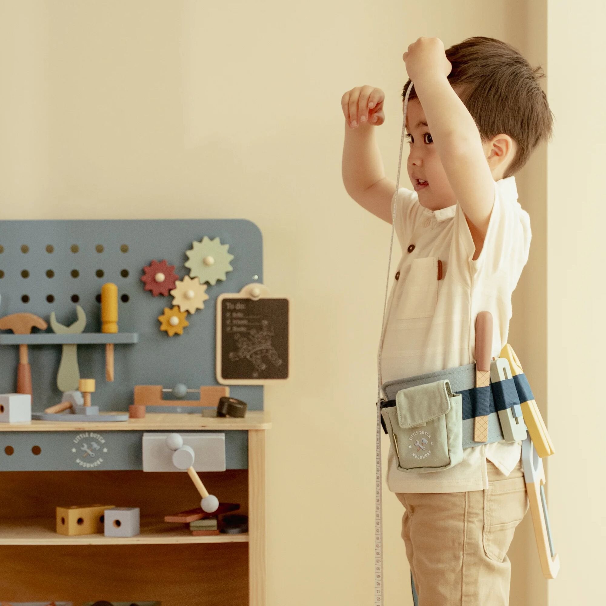 Enfant portant la ceinture à outils en bois Little Dutch