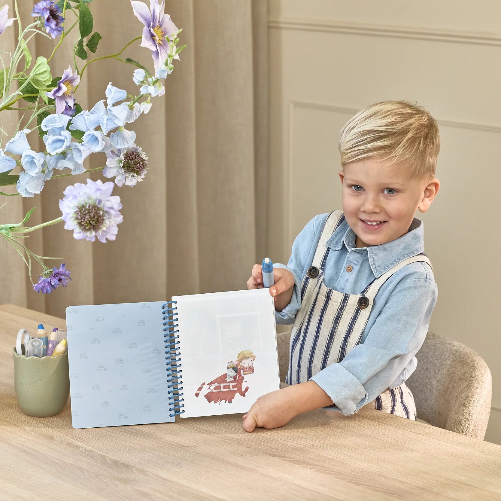 Enfant coloriant à l'eau avec le cahier Jim Little Dutch