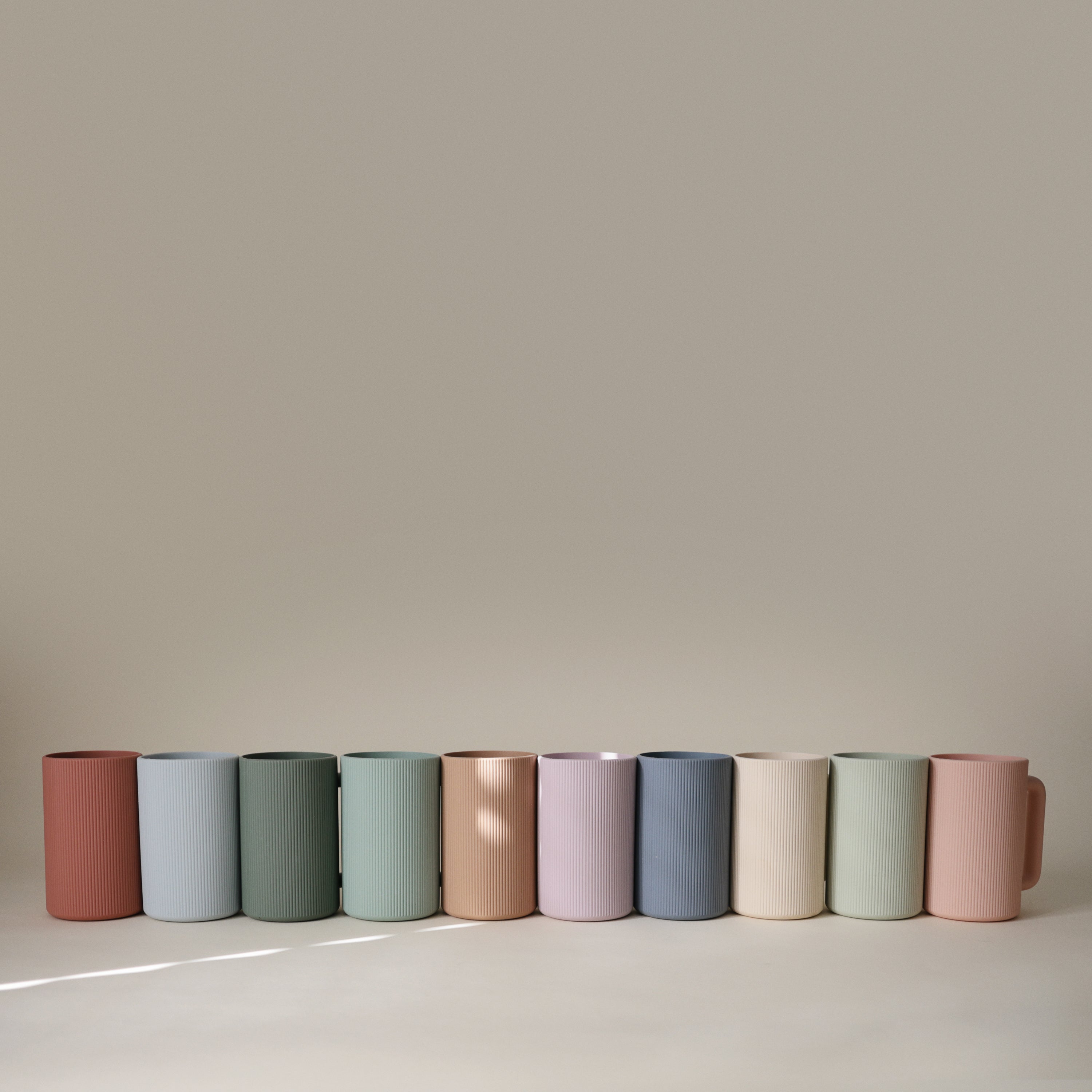 Gobelets de rinçage Mushie aux coloris pastel alignés