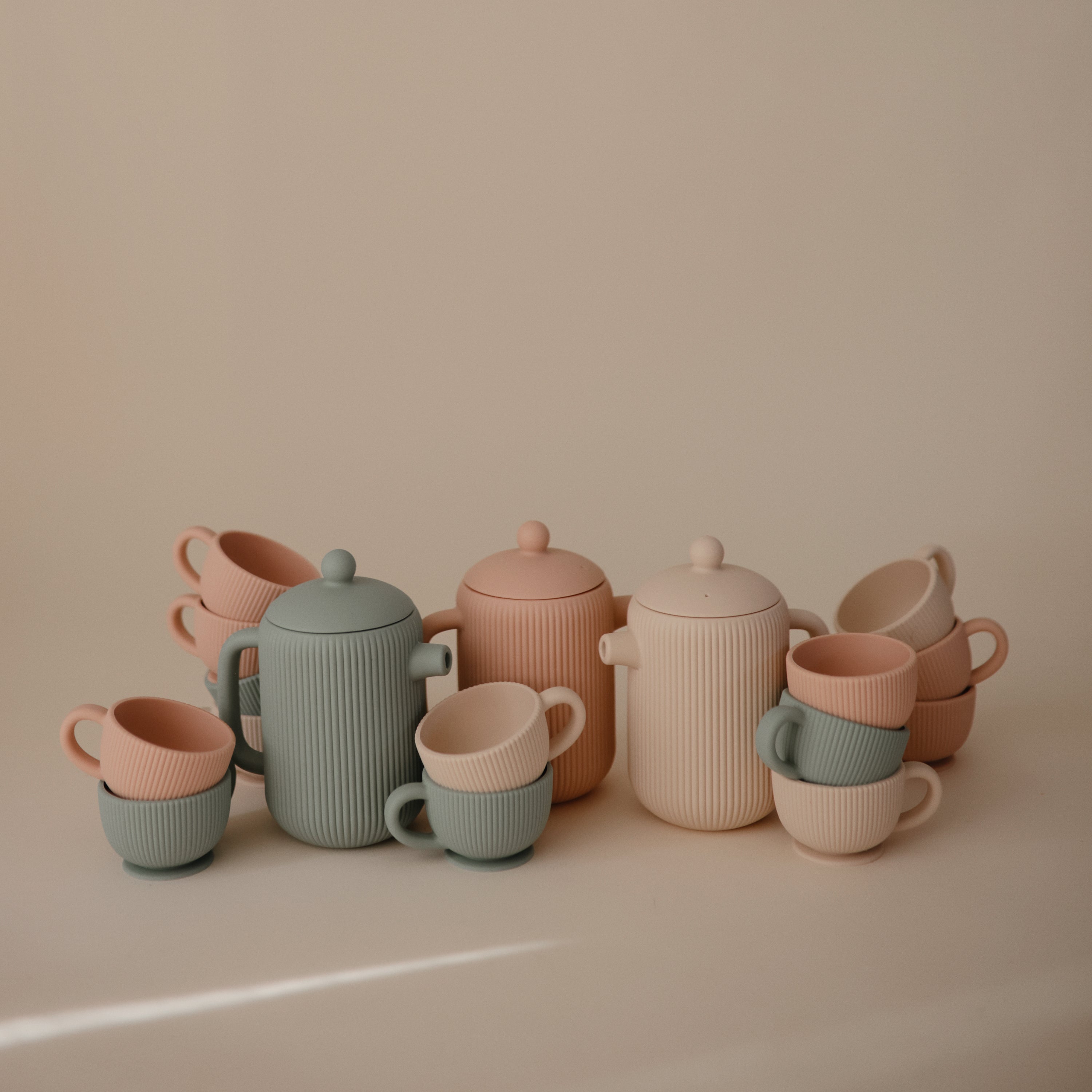 Dînettes Mushie aux coloris pastel sur fond beige