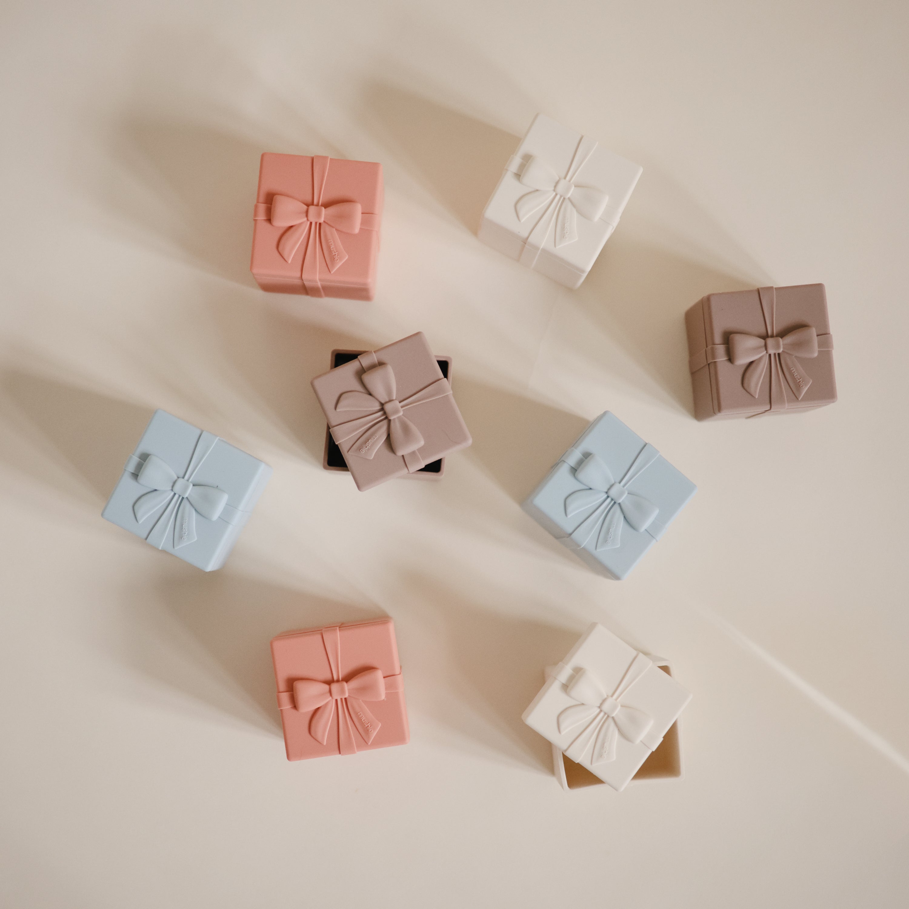 Paquets cadeaux en silicone Mushie ouverts avec un jouet caché à l'intérieur