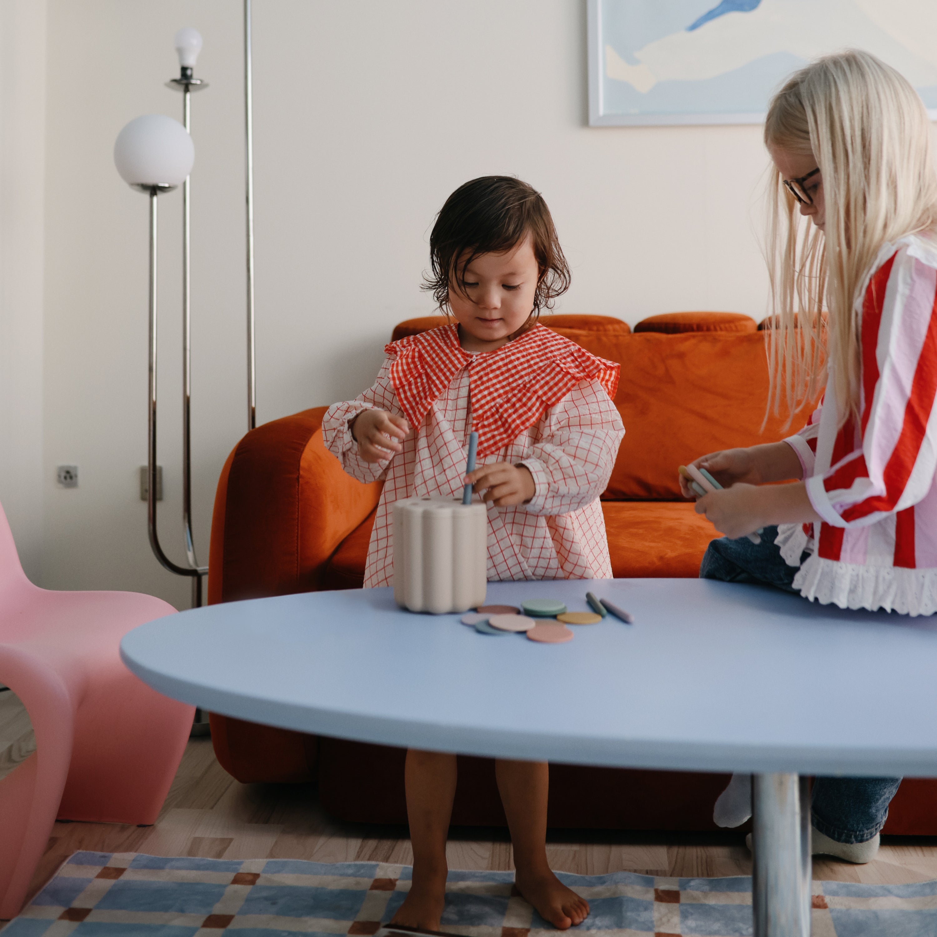 Deux enfants jouant à table avec la boîte de tri Mushie