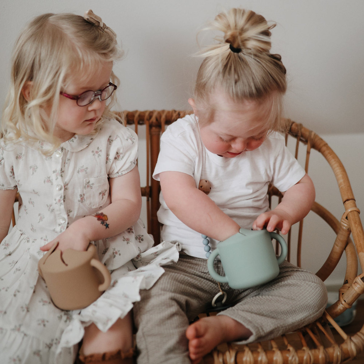 Deux tout-petits partageant un gobelet à goûter Mushie