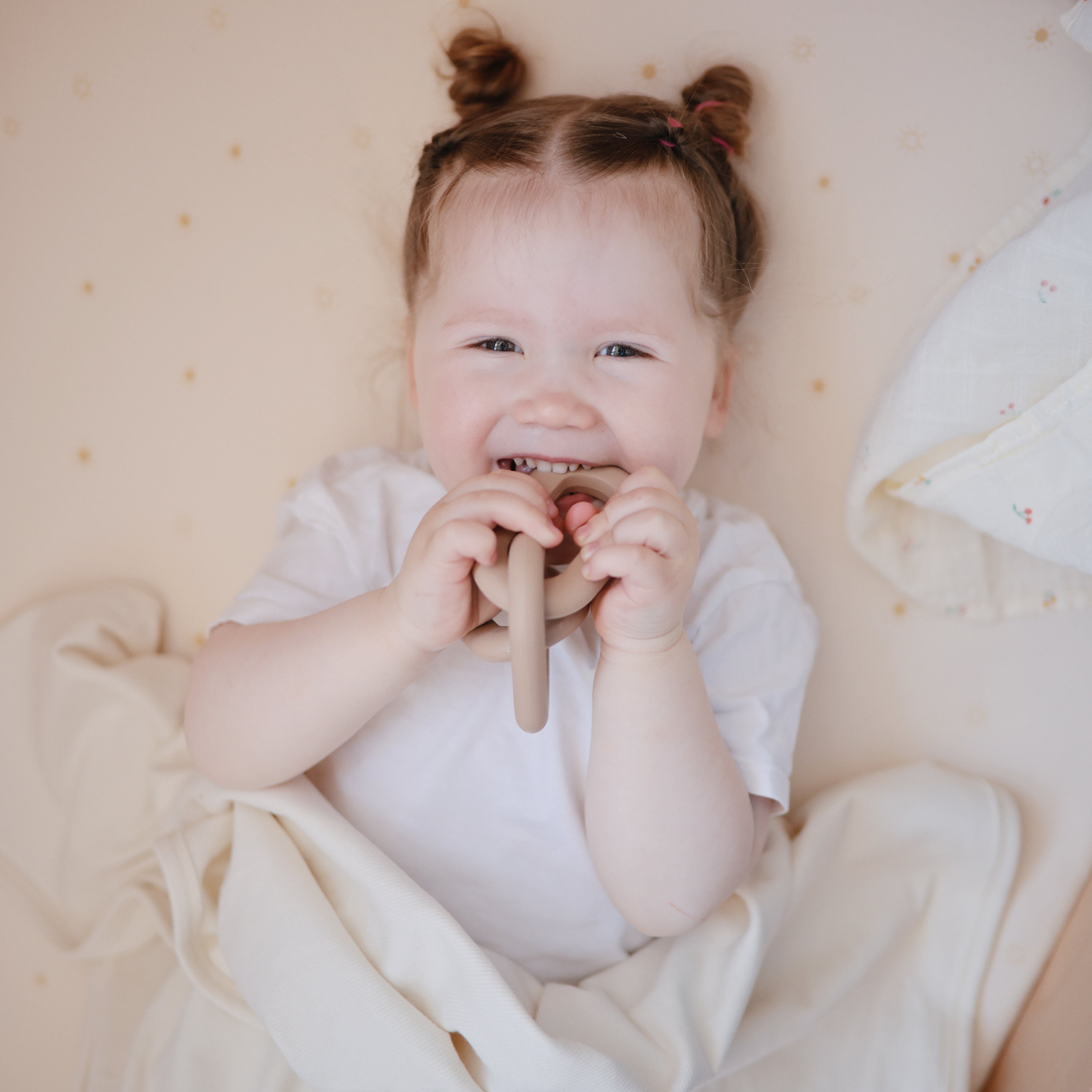 Bébé mordillant l'anneau de dentition Maillons Mushie