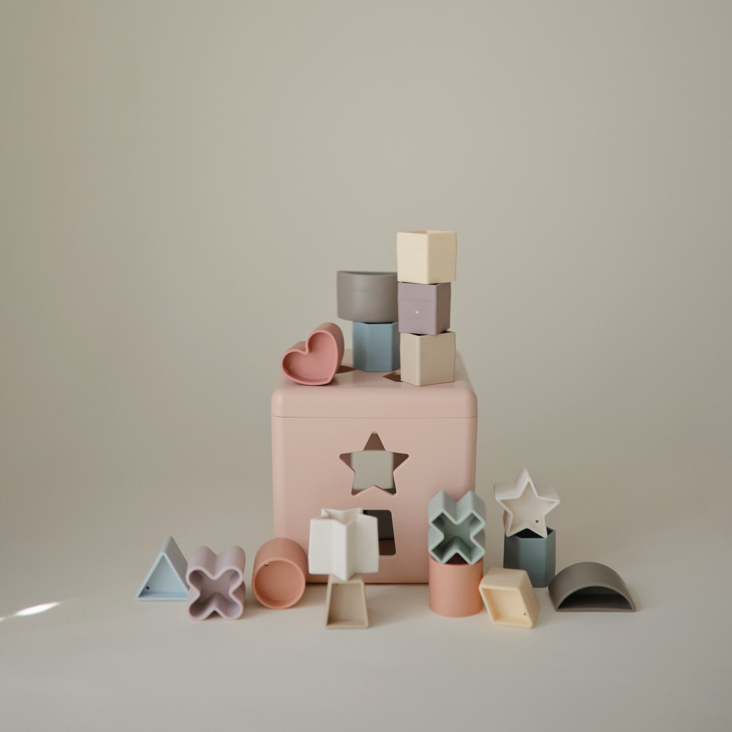 Boîte à formes Mushie rose pastel et ses formes