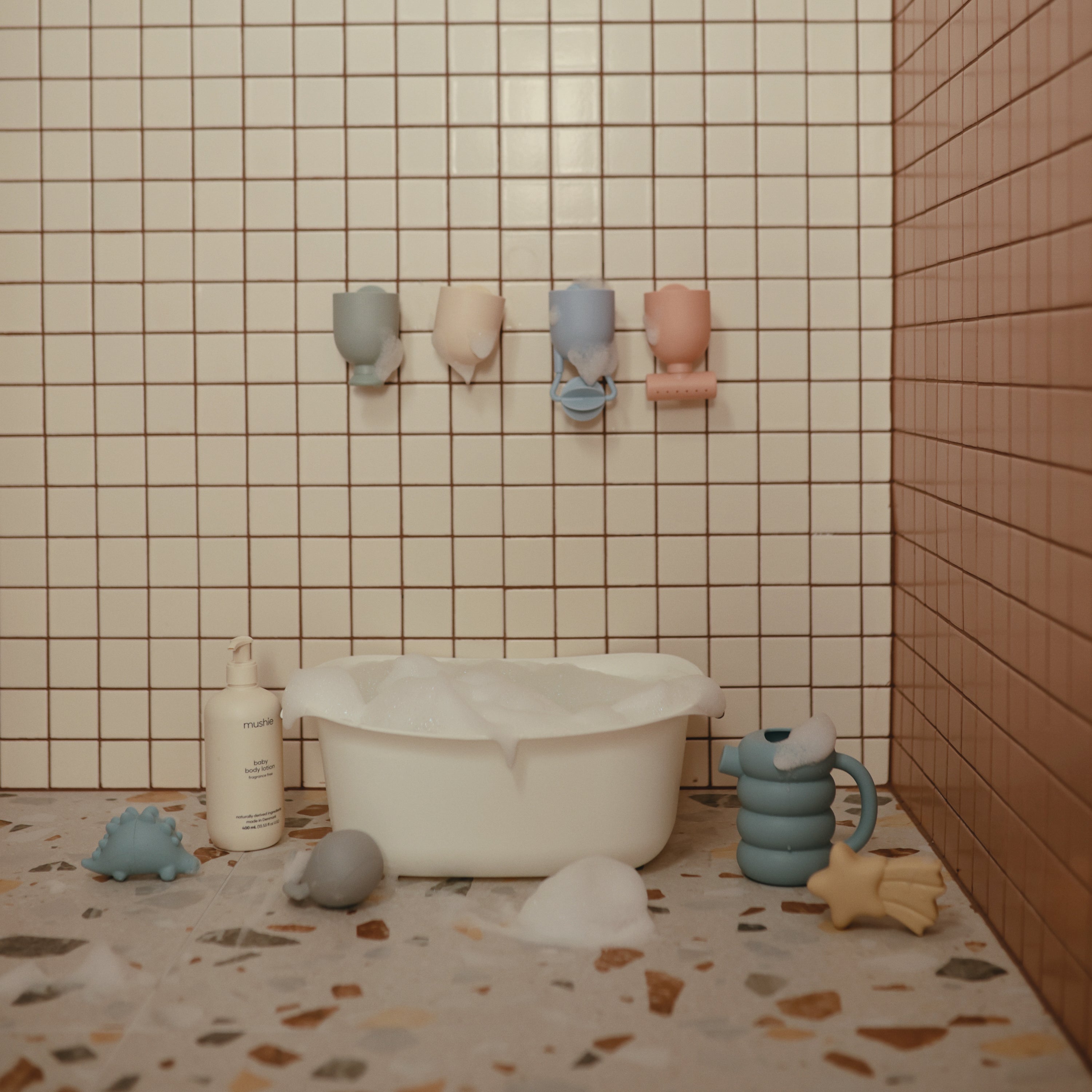 Salle de bain avec le set Pour and Play Mushie fixé au mur