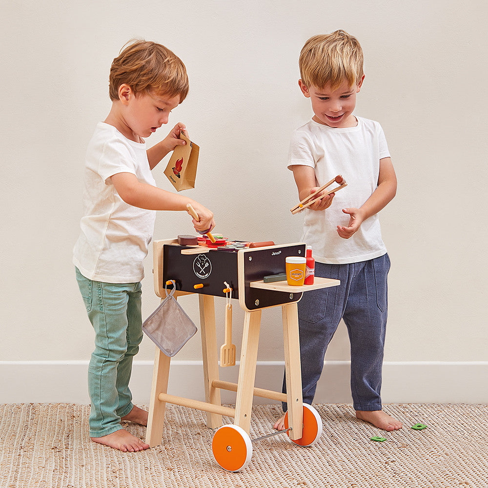 Enfant jouant avec le barbecue en bois Janod