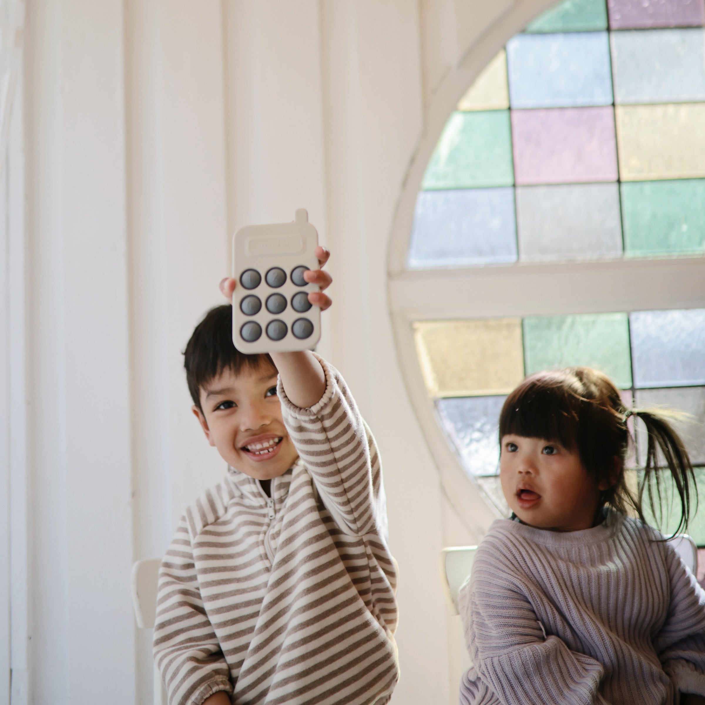 Enfants jouant avec le téléphone à presser Mushie