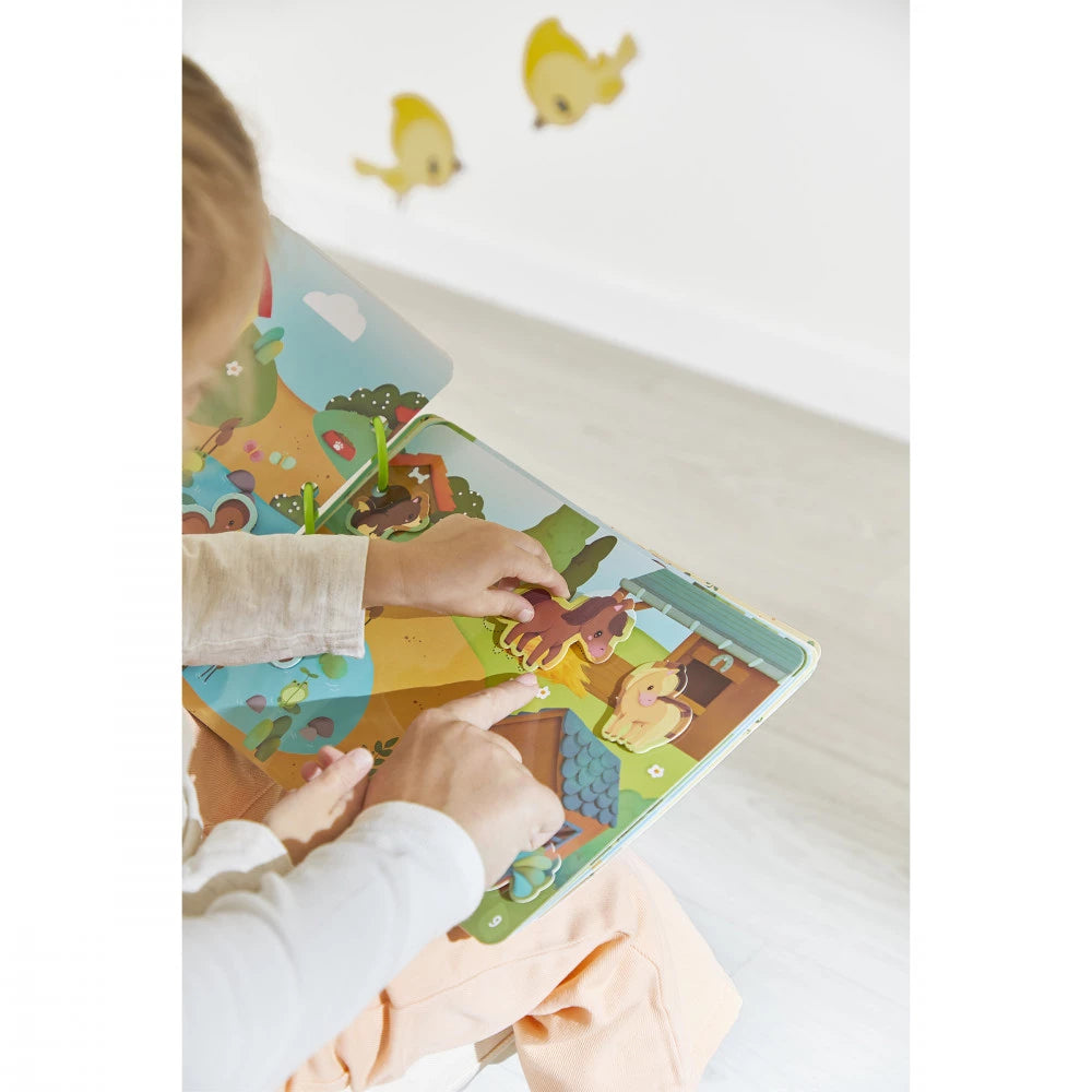 Enfant jouant avec le Busy Book de la ferme Janod