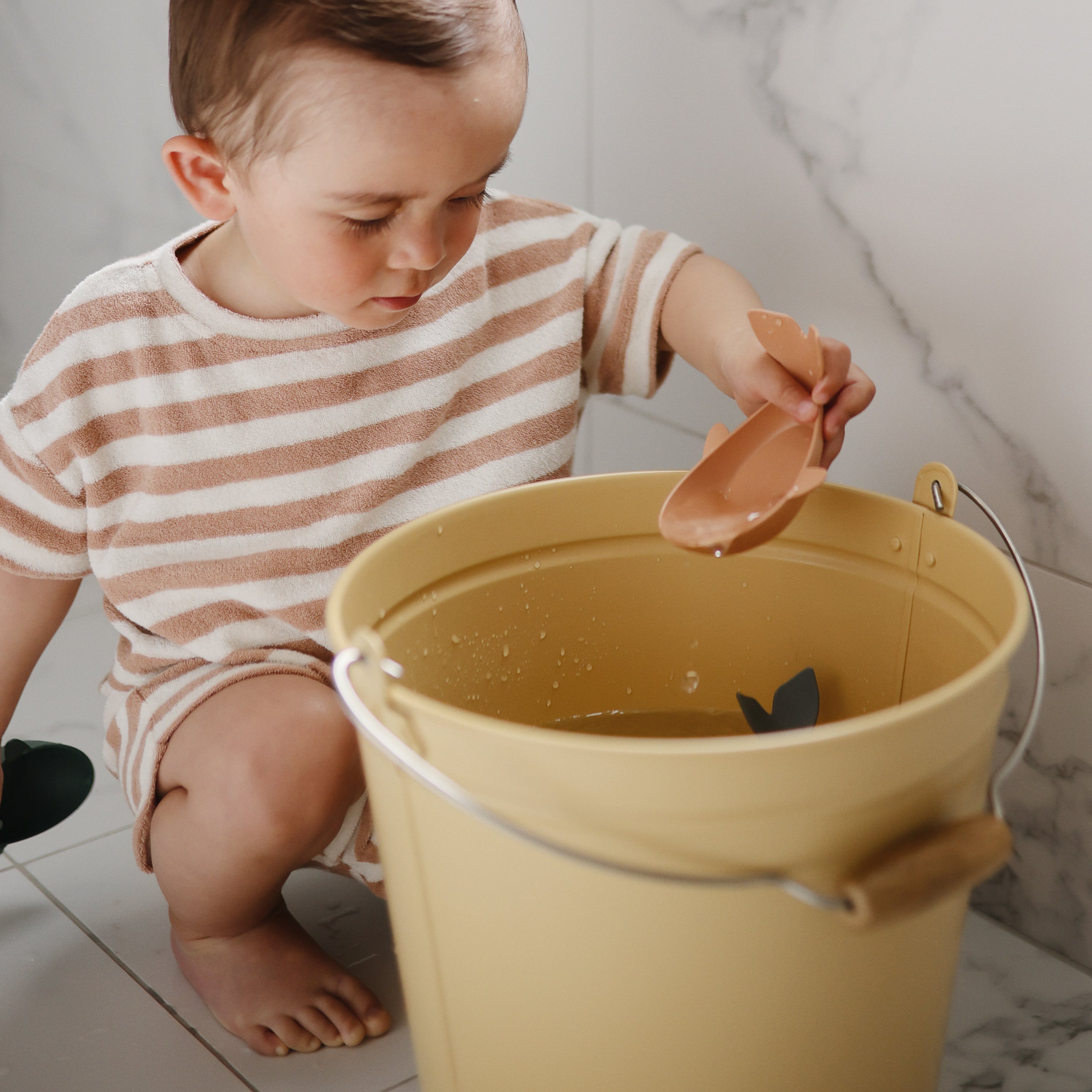 Enfant jouant avec les baleines de bain Mushie