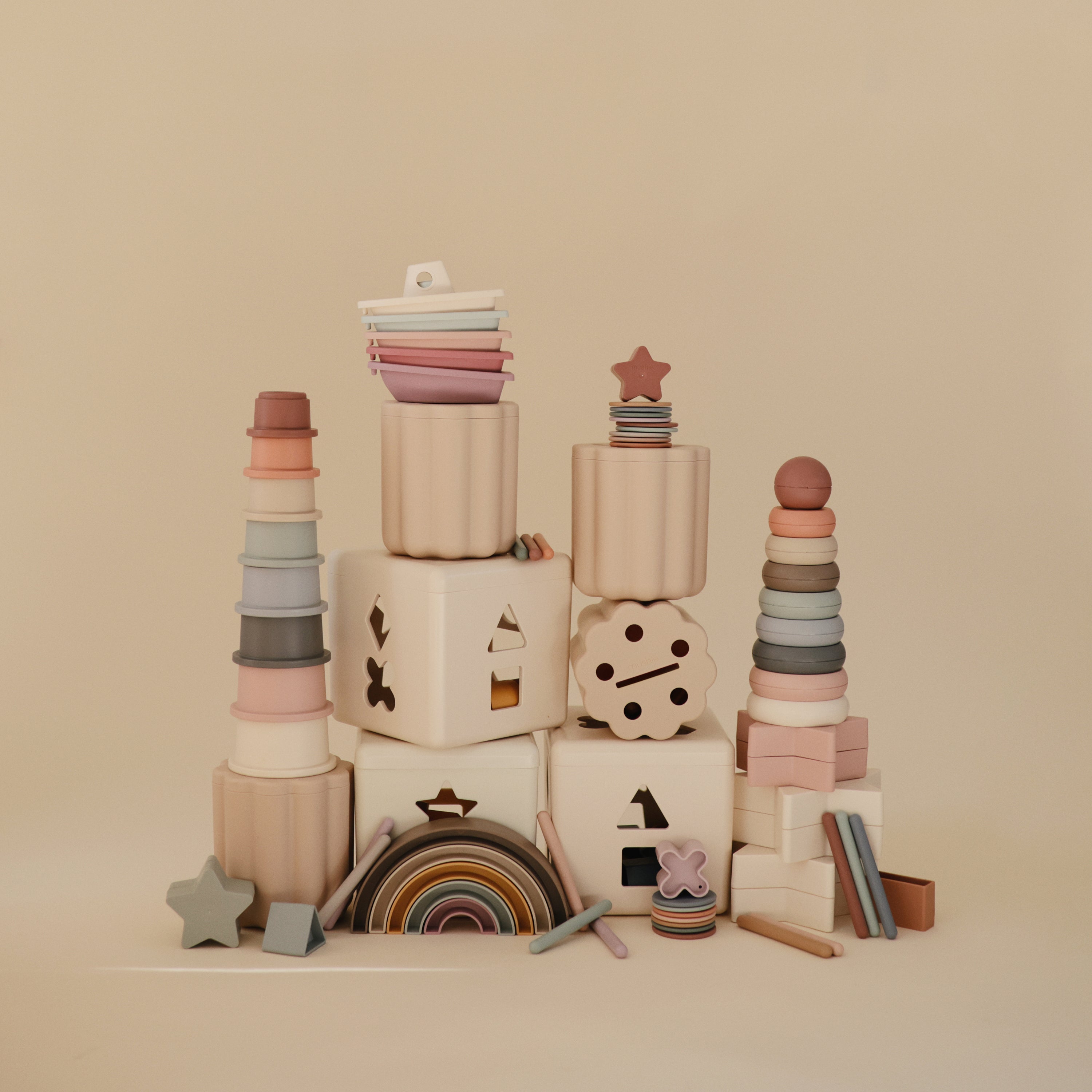 Boîte de tri pièces et tubes Mushie sur fond beige