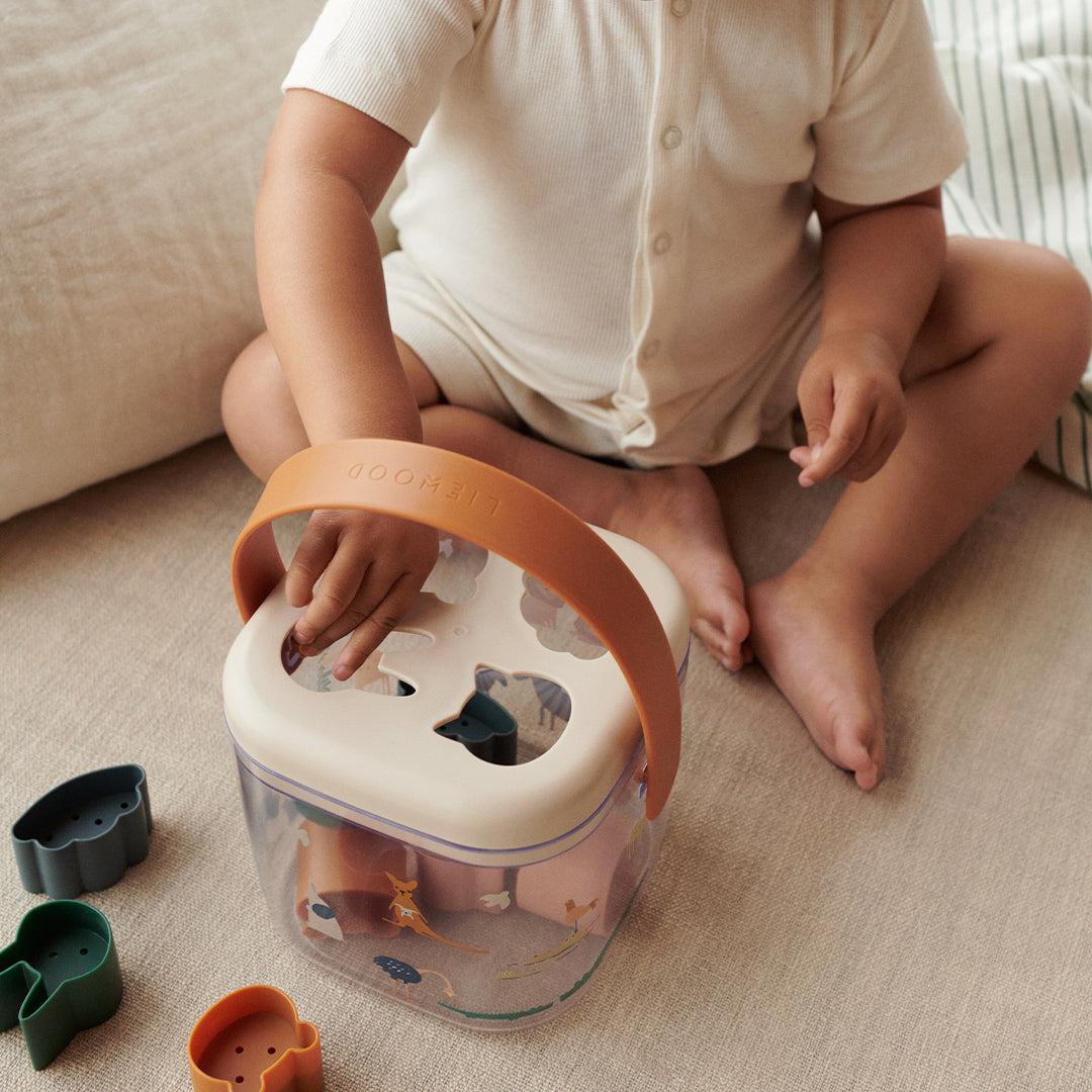 Enfant jouant avec la boîte à puzzle Lucinda Liewood