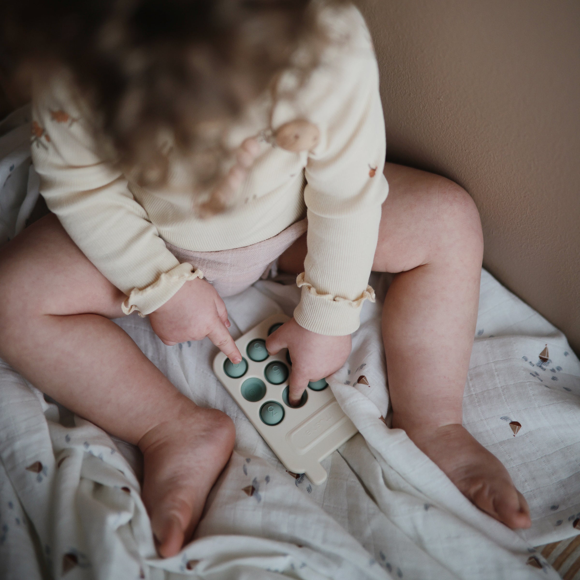 Enfant pressant les touches du téléphone Mushie