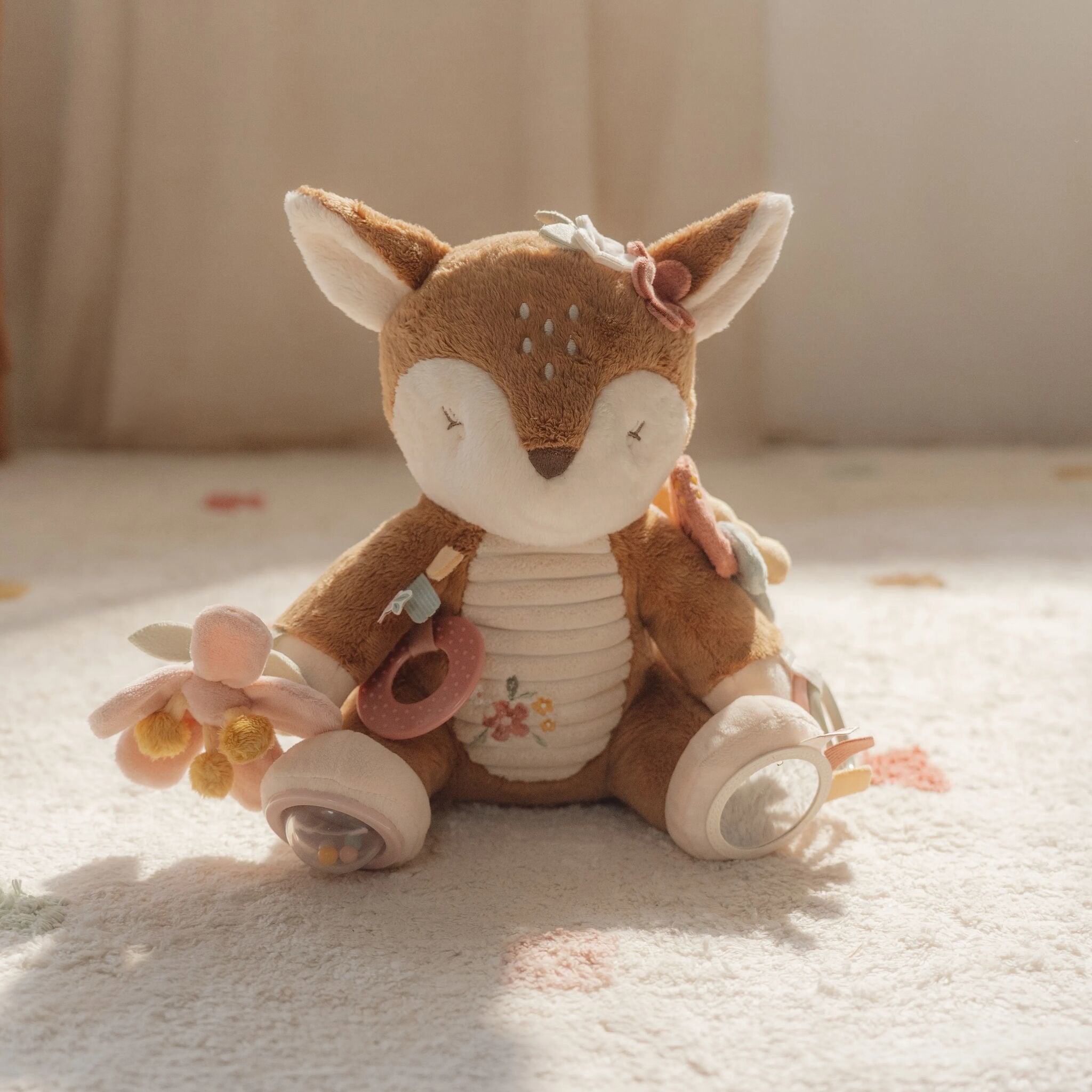 Bébé jouant avec la peluche d'activités faon Little Dutch
