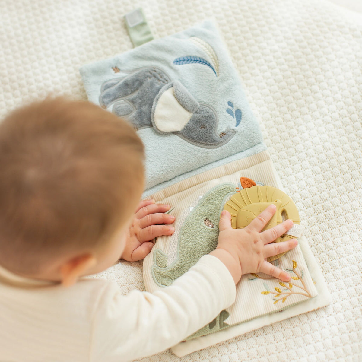 Bébé découvrant le livret en tissu Safari Friends