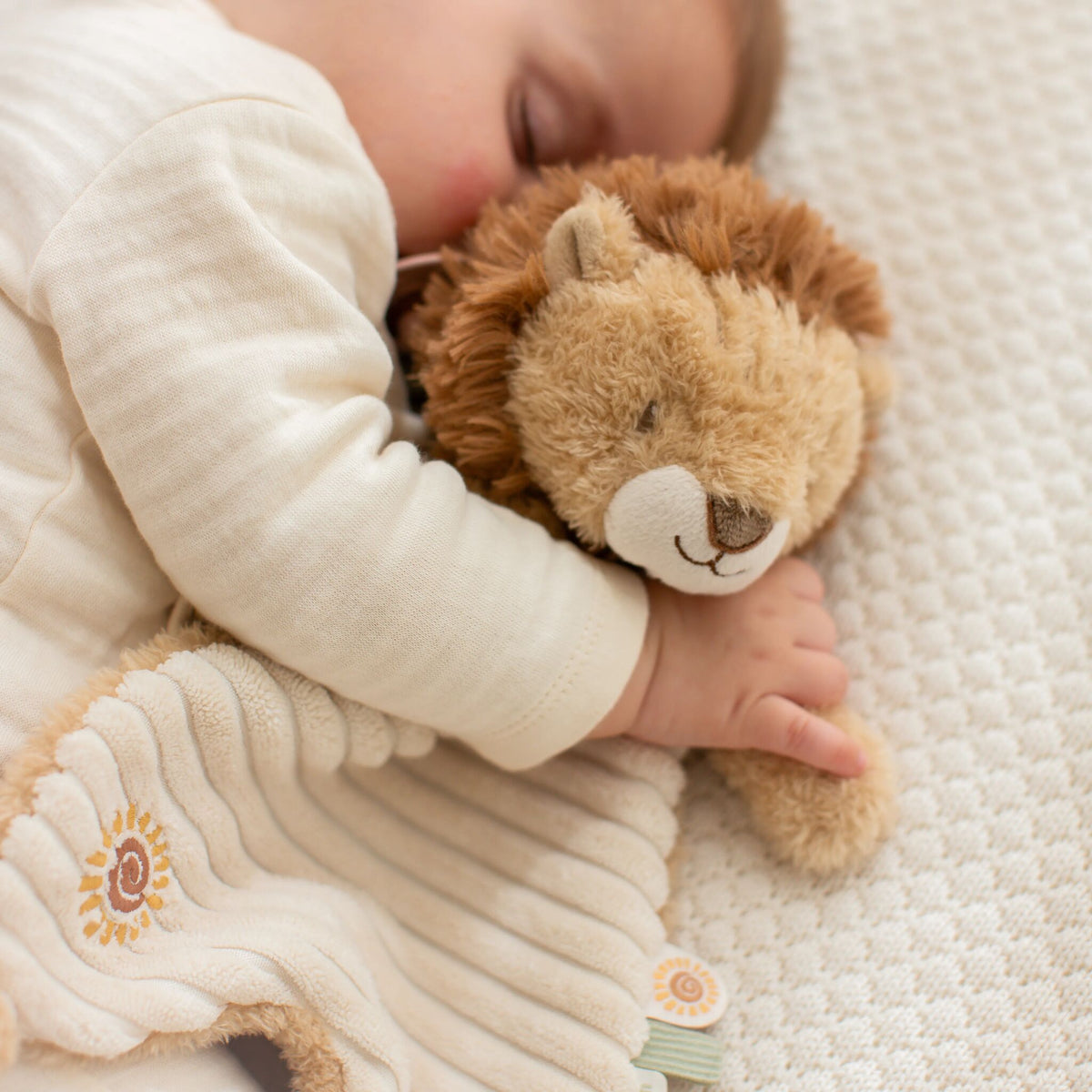Doudou lion Safari Friends dans un lit de bébé