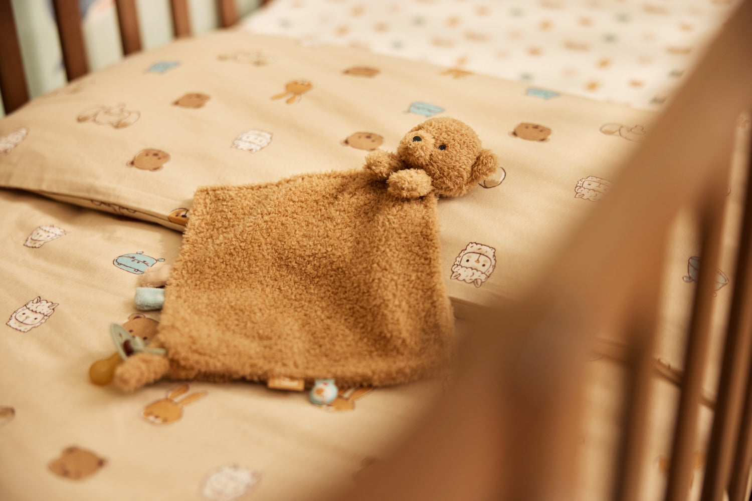 Doudou attache sucette Bear Brave Jollein tenu par un bébé