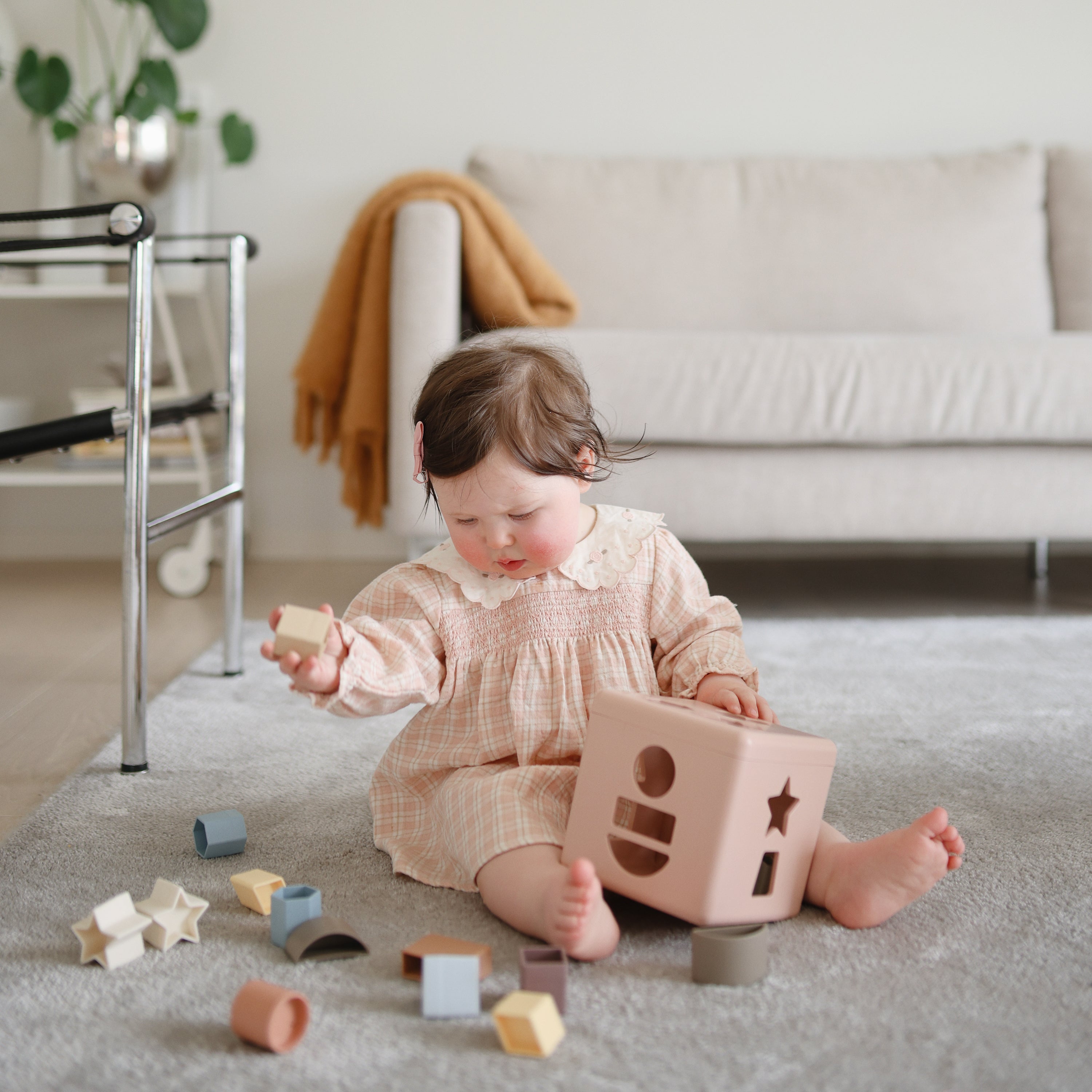 Bébé explorant la boîte à formes Mushie