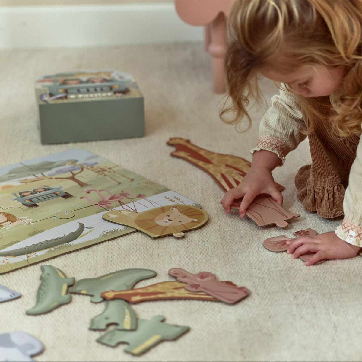 Petites mains posant une pièce de puzzle Safari Friends