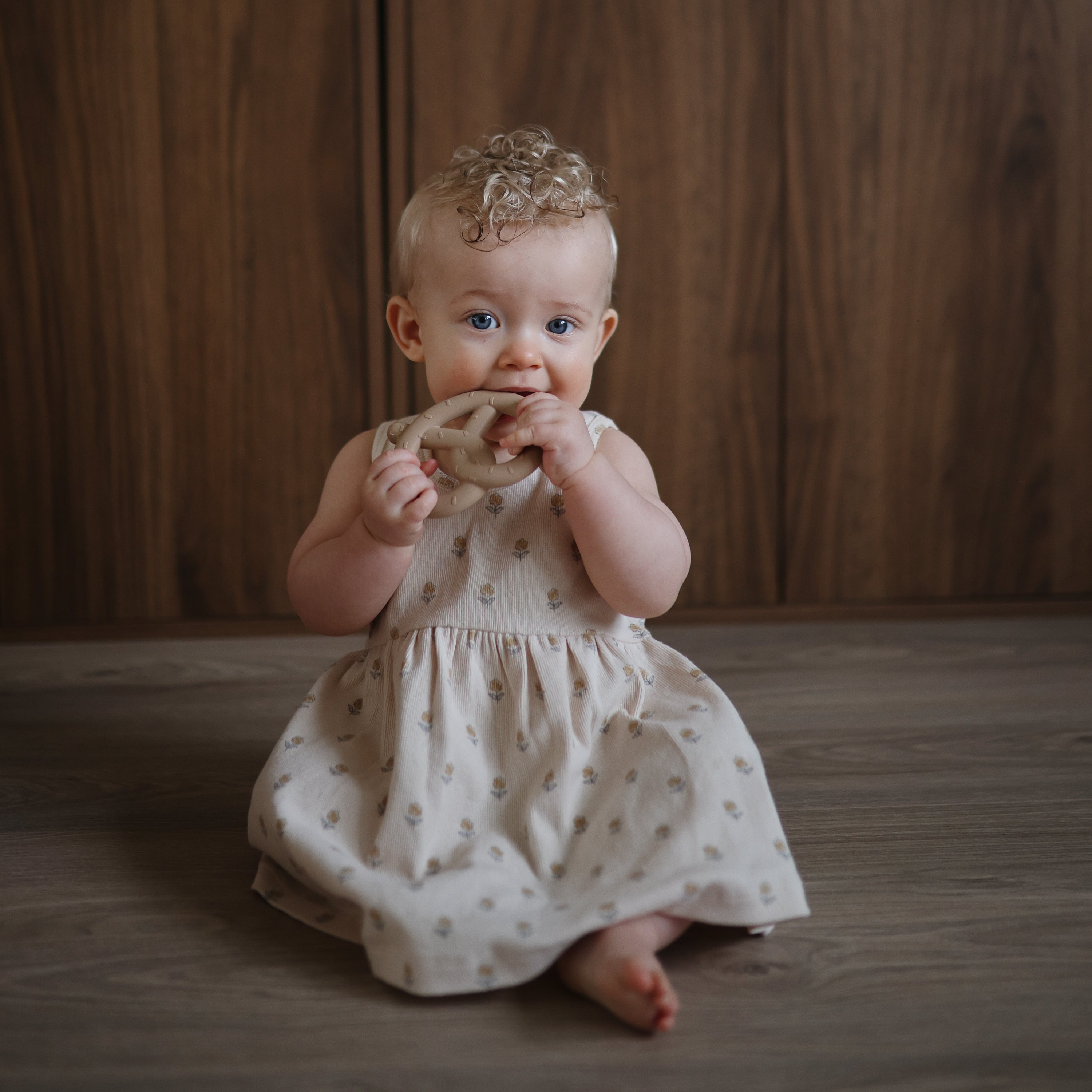 Bébé tenant l'anneau de dentition Bretzel Mushie