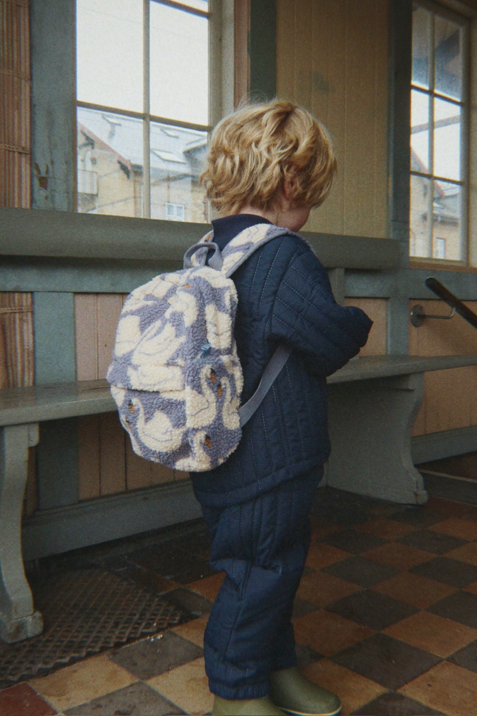 Enfant portant le sac à dos Jody Teddy Swan Konges Sløjd sur le chemin de l'école
