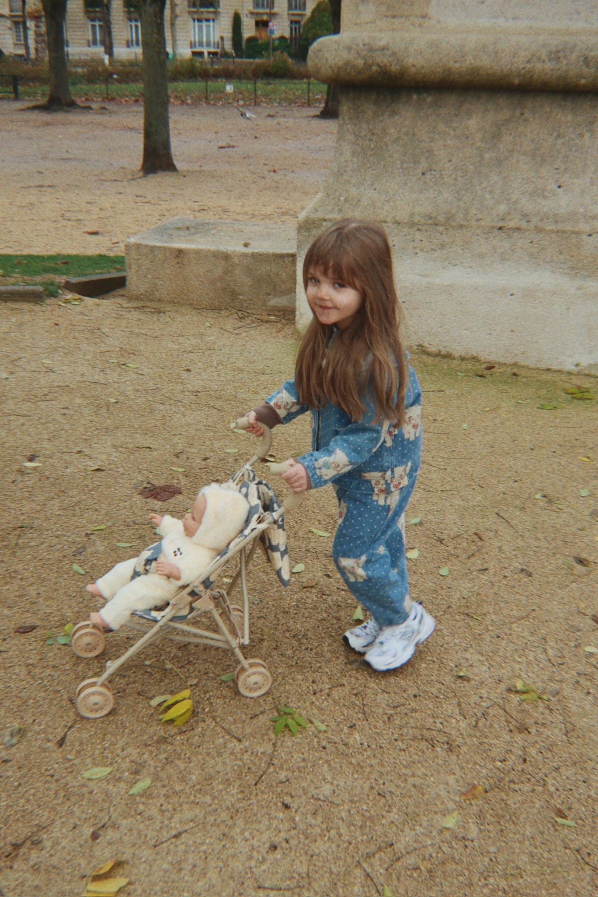 Scène de jeu d'imitation avec la poussette Swan et une poupée installée dedans