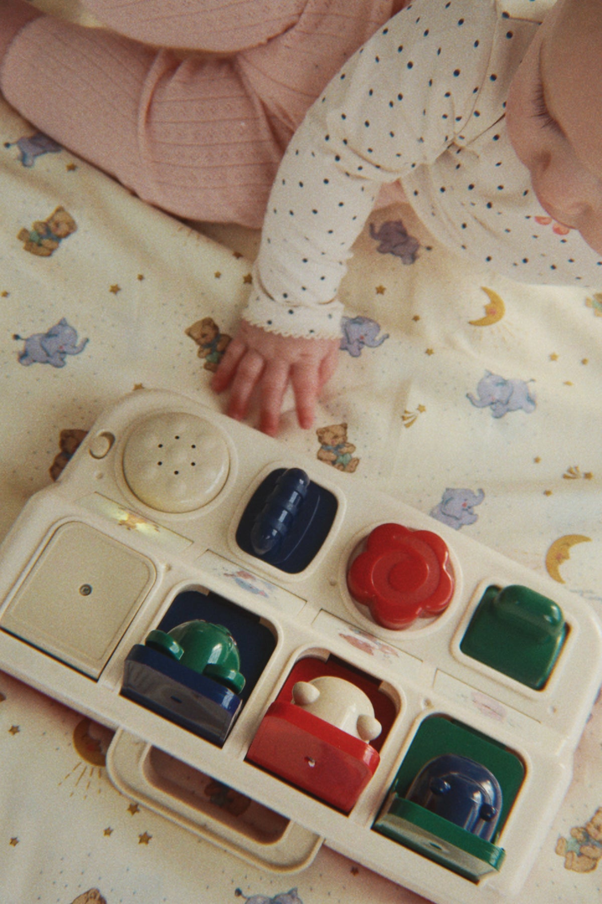 Enfant actionnant les boutons du tableau musical Pop Up pour faire surgir un animal