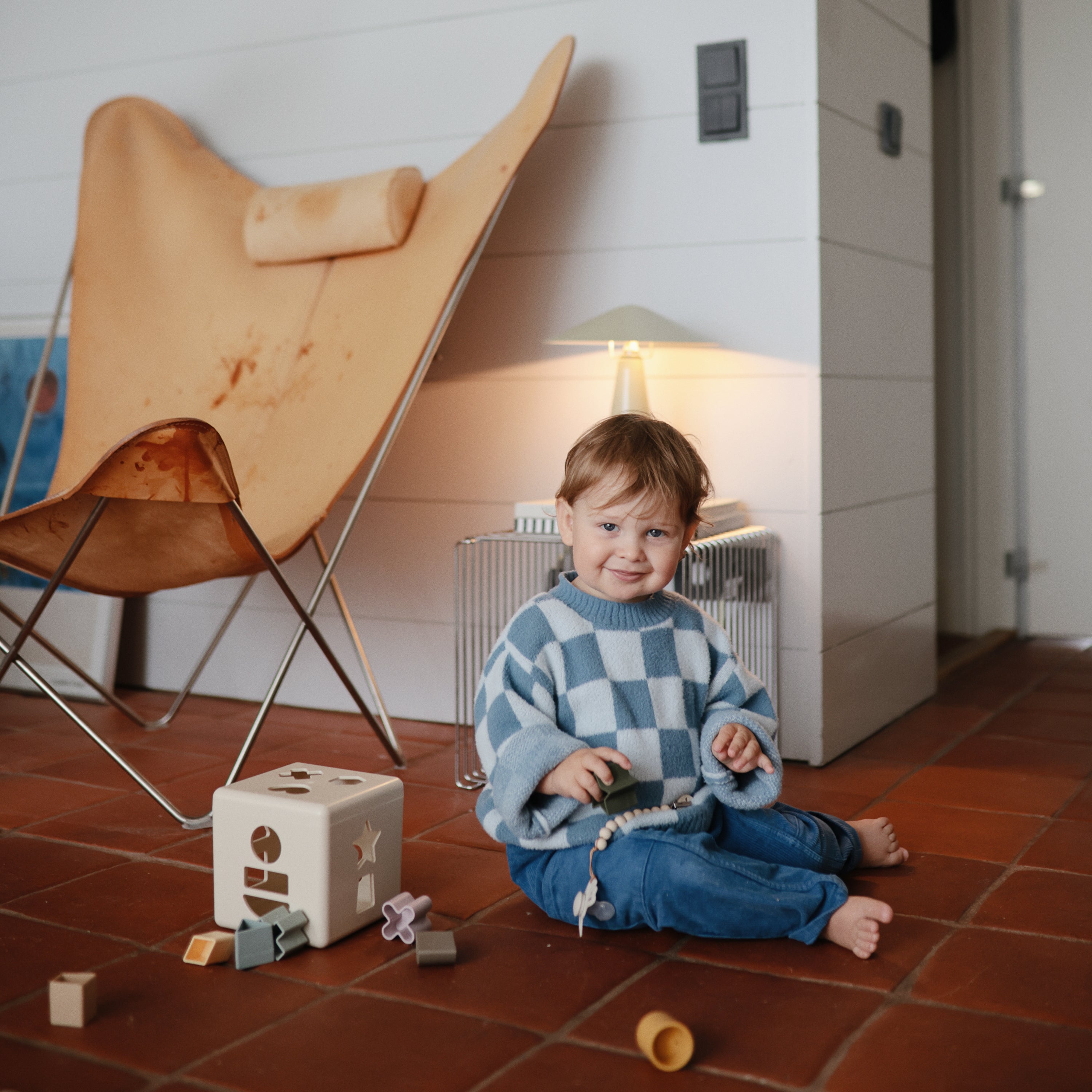 Enfant jouant avec la boîte à formes Mushie