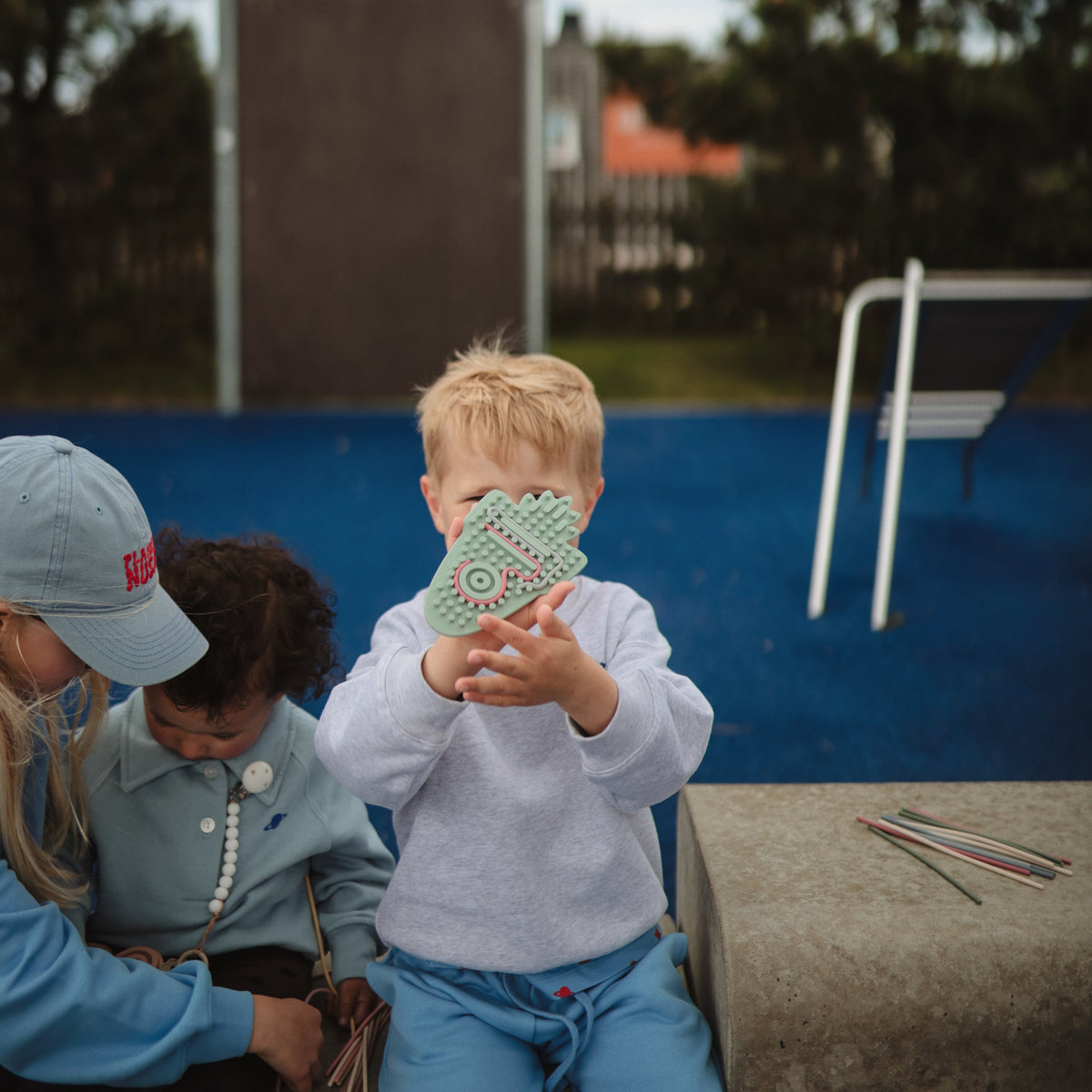 Enfant au parc avec son jouet sensoriel Mushie