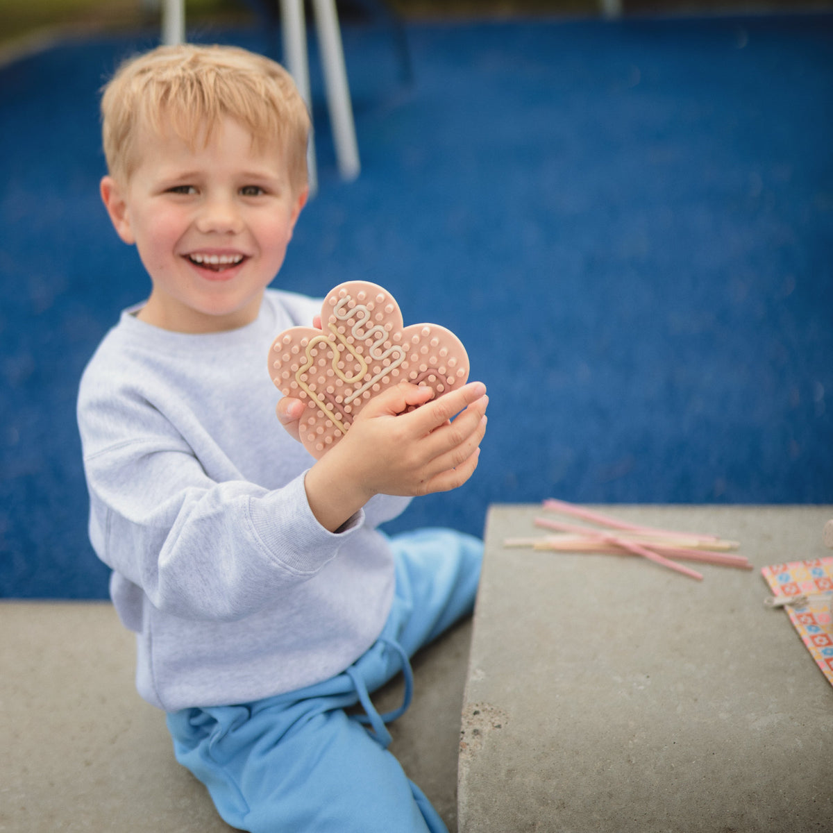 Enfant tenant un jouet sensoriel Mushie en silicone