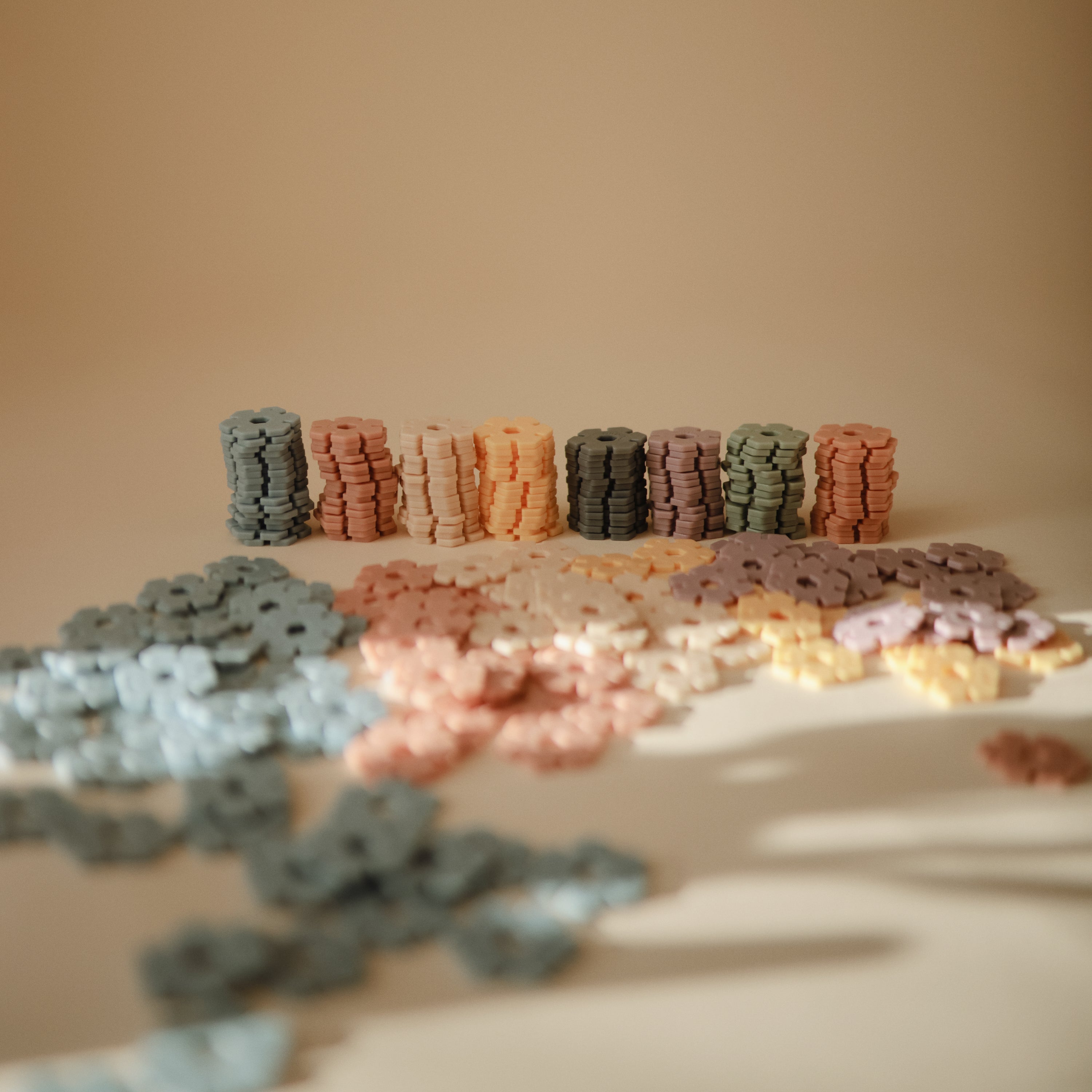 Pièces Hex Connect Mushie en forme de fleurs sur fond neutre