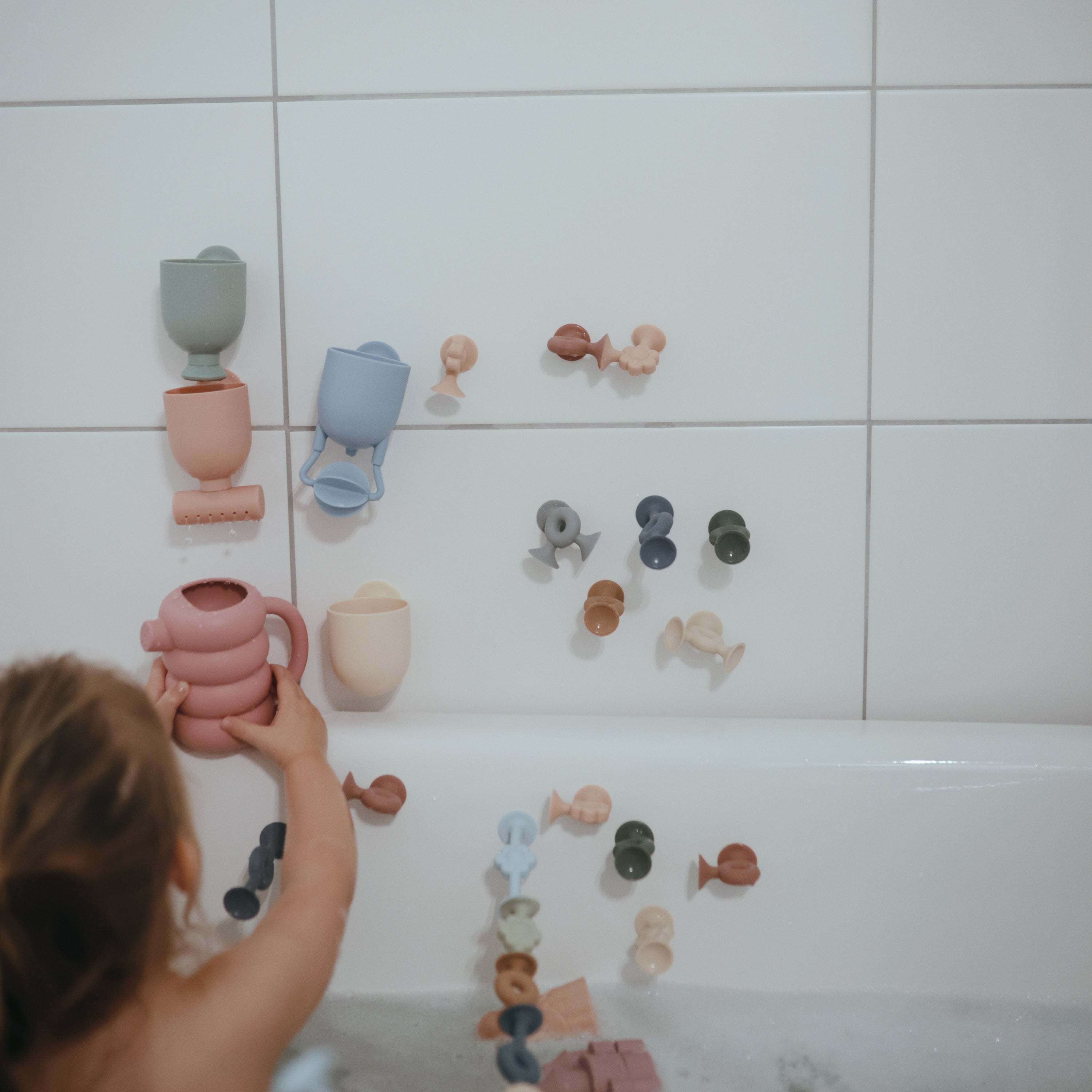 Enfant jouant dans le bain avec le set Pour and Play Mushie