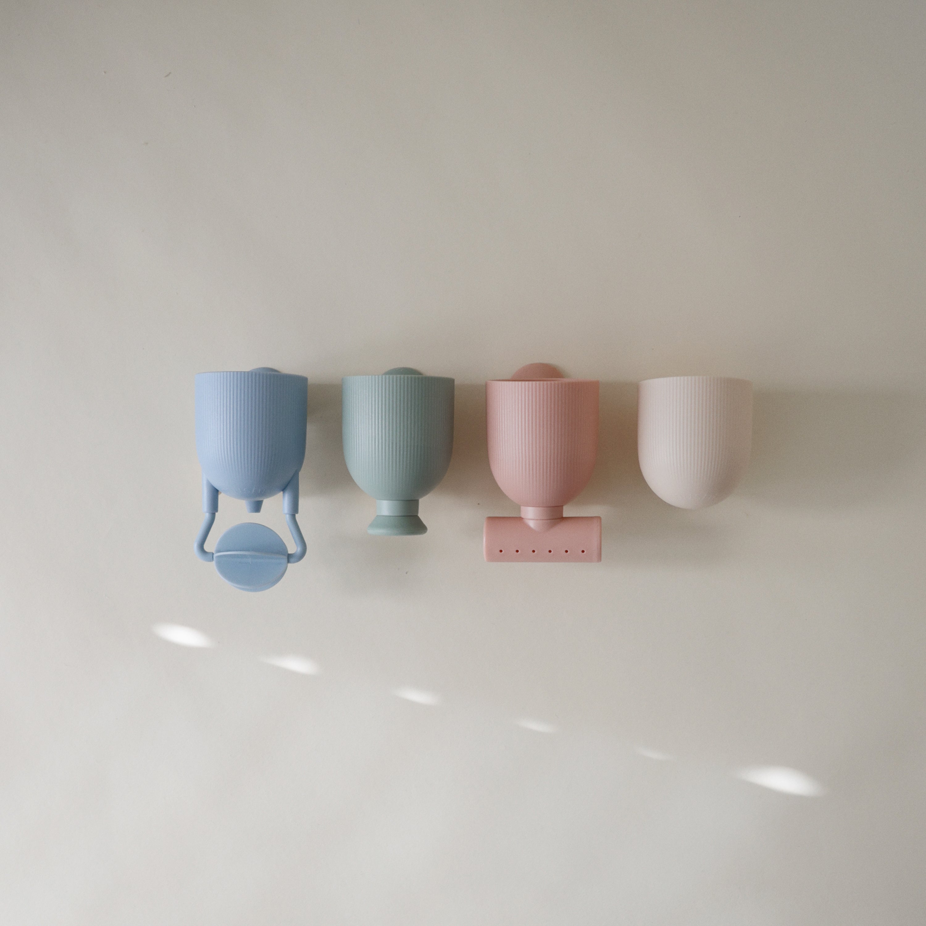 Gobelets du set de bain Pour and Play Mushie et leurs accessoires