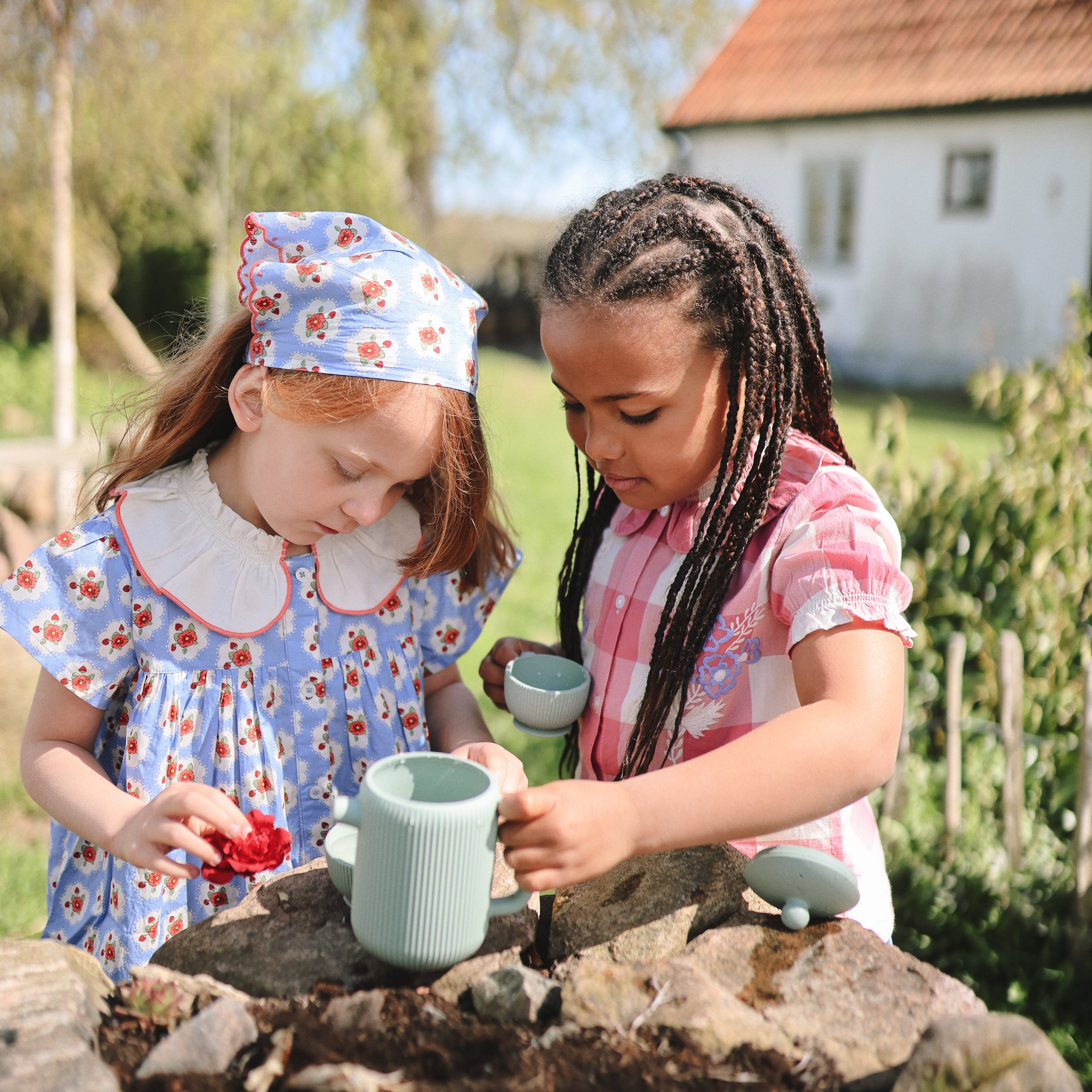 Deux enfants jouant au goûter avec la dînette Mushie en extérieur