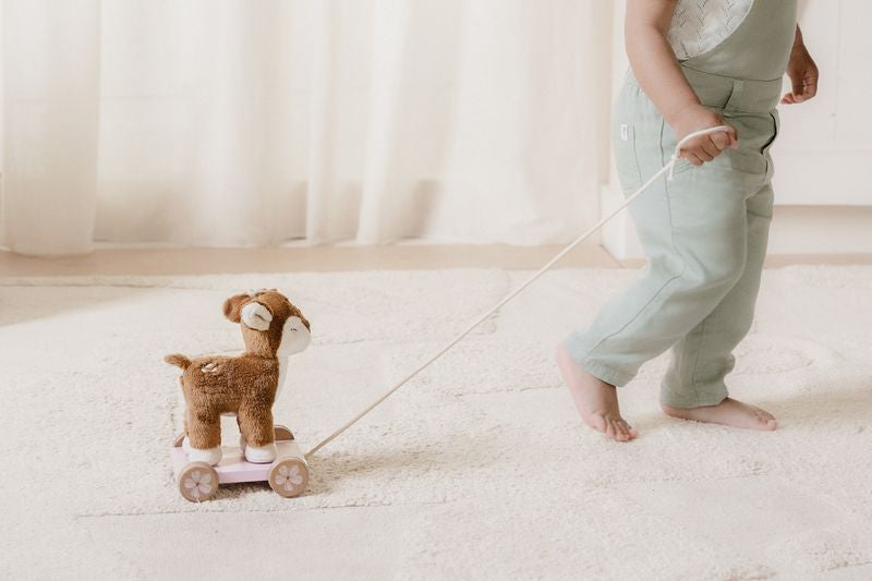 Enfant jouant avec la peluche à tirer faon Fairy Garden