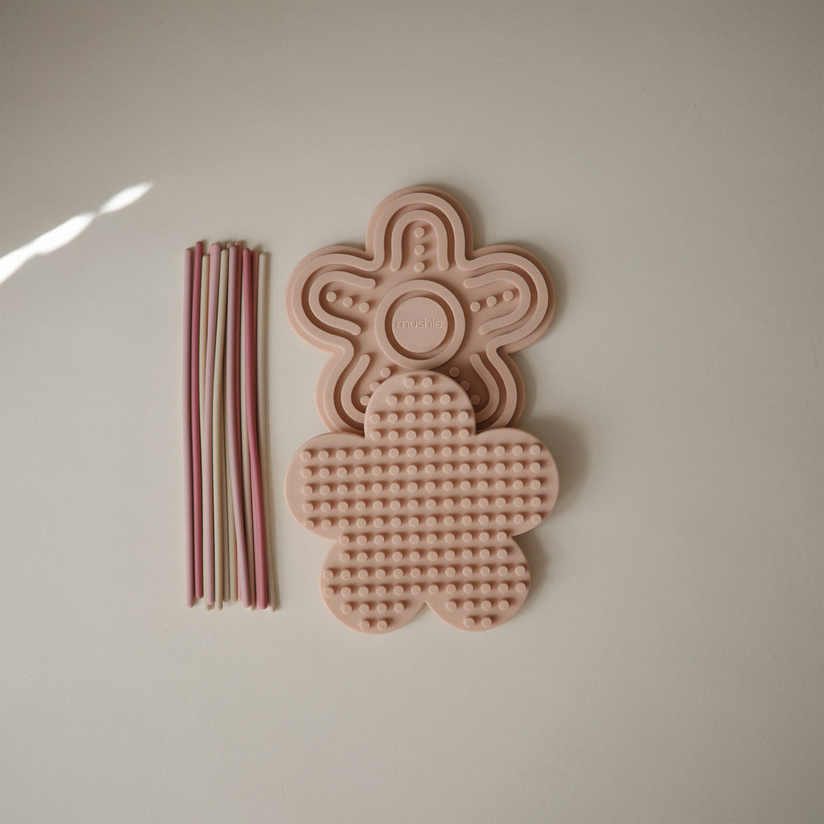 Jouets sensoriels Mushie et cordons pastel