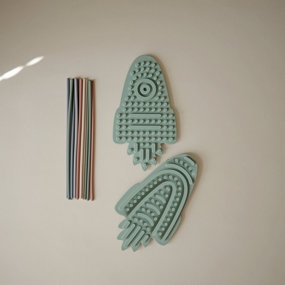 Cordons multicolores en silicone à enfoncer dans le jouet sensoriel Mushie