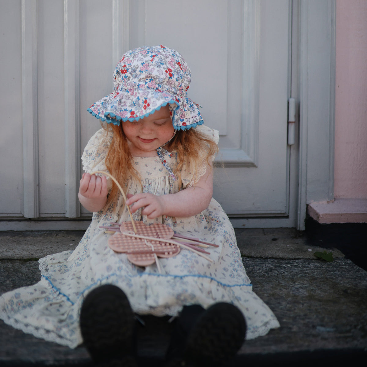 Enfant concentré sur son jouet sensoriel Mushie