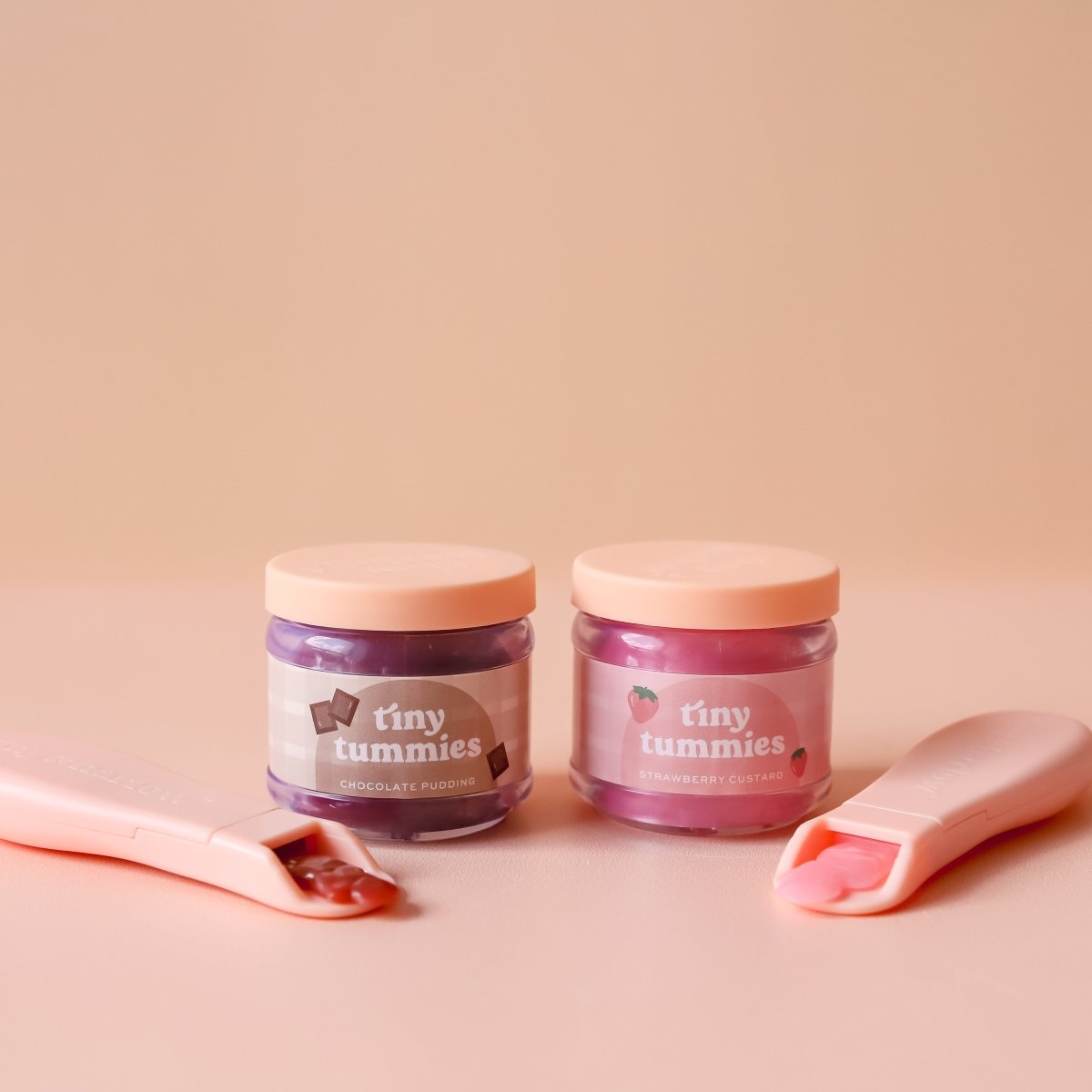 Cuillère magique garnie de crème fraise devant le petit pot Tiny Harlow